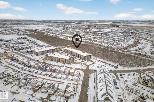 Aerial view of the community, showcasing snow-covered residential buildings, streets, and natural areas - 301 1070 Mcconachie Boulevard, Edmonton, AB - Outdoor With View