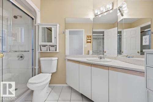 Bathroom featuring a glass-enclosed shower, a vanity with a white countertop and integrated sink, and white cabinetry - 3772 30 Street, Edmonton, AB - Indoor Photo Showing Bathroom