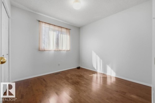 This room features hardwood floors and white walls, creating a bright and inviting space - 3772 30 Street, Edmonton, AB - Indoor Photo Showing Other Room