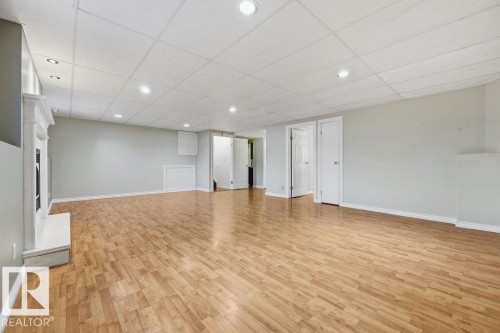 Expansive living area featuring hardwood flooring, a decorative fireplace, and recessed lighting - 3772 30 Street, Edmonton, AB - Indoor