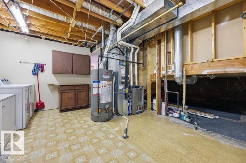 Utility room featuring exposed ceiling joists, overhead lighting, and patterned flooring - 3772 30 Street, Edmonton, AB - Indoor