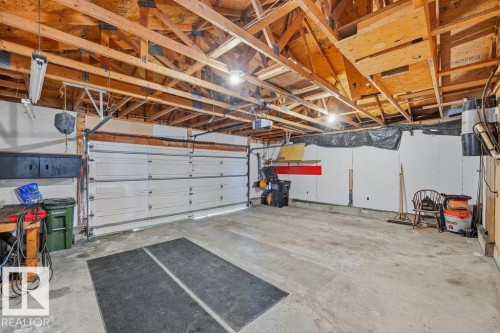 Spacious garage featuring exposed wooden beams, a concrete floor, and two garage doors - 3772 30 Street, Edmonton, AB - Indoor Photo Showing Garage