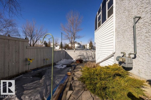The property features a private fenced yard with a concrete patio area and mature landscaping - 3772 30 Street, Edmonton, AB - Outdoor