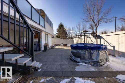 The property features a patio area with stone paving, a privacy fence, and a covered outdoor spa - 3772 30 Street, Edmonton, AB - Outdoor