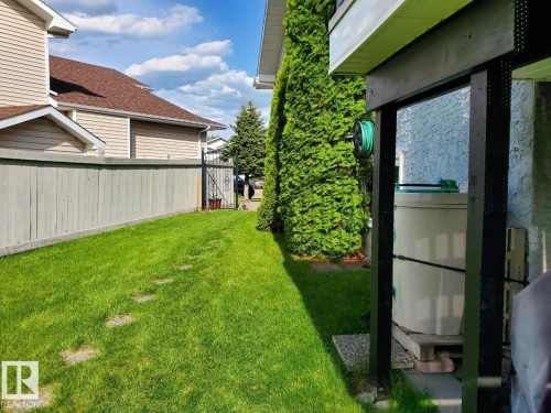 The property features a well-maintained lawn with stepping stones, bordered by a wooden fence - 3772 30 Street, Edmonton, AB - Outdoor