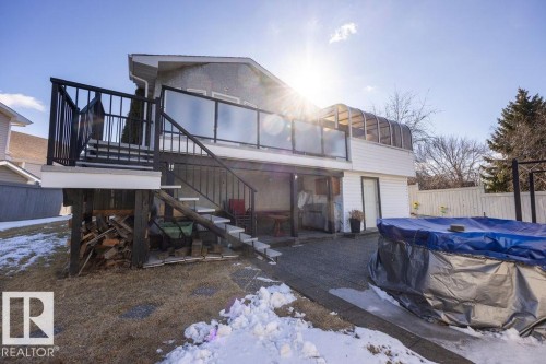The property features a multi-level deck with glass panel railings and stairs leading to the yard - 3772 30 Street, Edmonton, AB - Outdoor
