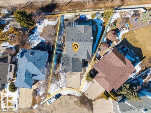 Aerial view of the property, featuring a gray roof, a driveway, and a partially snow-covered yard with mature trees - 3772 30 Street, Edmonton, AB - Outdoor With View