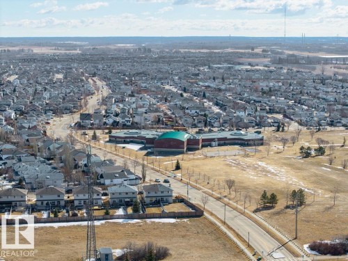 Aerial view showcasing the surrounding residential area with properties featuring gray roofs, a large building with a green roof, and expanses of open land - 3772 30 Street, Edmonton, AB - Outdoor With View