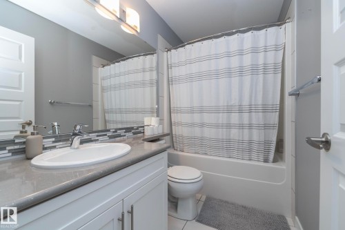 Bathroom featuring a white vanity with a light-colored countertop, a rectangular sink, and a chrome faucet - 7359 179 Avenue, Edmonton, AB - Indoor Photo Showing Bathroom