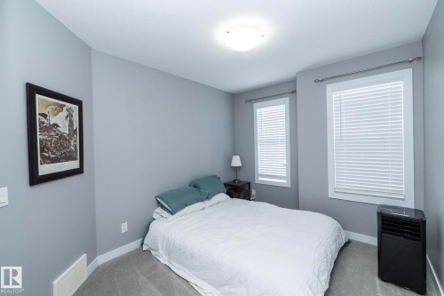 This room features two windows with white blinds, light gray walls, and carpeting - 7359 179 Avenue, Edmonton, AB - Indoor Photo Showing Bedroom
