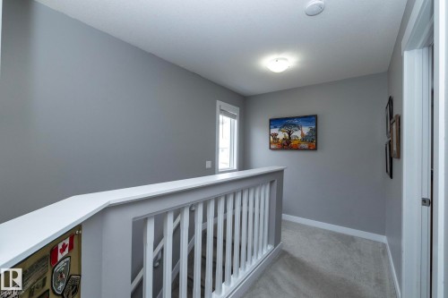The property features a hallway with light gray walls, white trim, and light-colored carpeting - 7359 179 Avenue, Edmonton, AB - Indoor Photo Showing Other Room