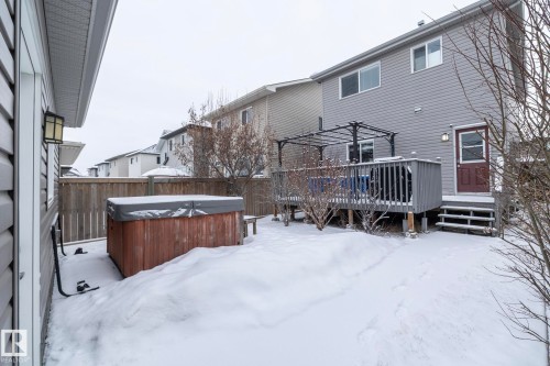 The property features a wooden deck with a black pergola, a hot tub, and a privacy fence - 7359 179 Avenue, Edmonton, AB - Outdoor With Deck Patio Veranda With Exterior