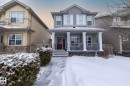 The property features a two-story facade with light gray siding and a covered front porch supported by white columns - 7359 179 Avenue, Edmonton, AB  - Outdoor With Deck Patio Veranda With Facade 