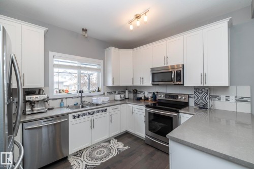 The kitchen features white cabinetry, stainless steel appliances, and light gray countertops - 7359 179 Avenue, Edmonton, AB - Indoor Photo Showing Kitchen With Stainless Steel Kitchen