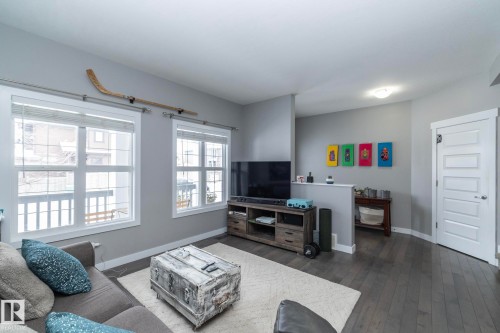 Living area featuring dark hardwood floors, light gray walls, and bright white trim around windows and doors - 7359 179 Avenue, Edmonton, AB - Indoor Photo Showing Living Room