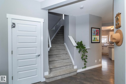 The property features a staircase with carpeted treads and white risers, complemented by a white handrail - 7359 179 Avenue, Edmonton, AB - Indoor Photo Showing Other Room