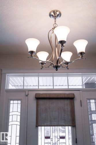 Overhead lighting fixture with five frosted glass shades and a brushed nickel finish - 307 Ravine Close, Devon, AB - Indoor Photo Showing Other Room