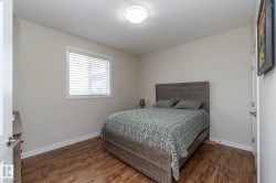 The room features hardwood style flooring and a window with blinds, allowing for adjustable natural light - 