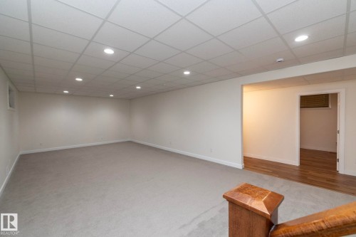 Spacious area featuring light grey carpeting, recessed lighting, and a white drop ceiling - 307 Ravine Close, Devon, AB - Indoor Photo Showing Other Room
