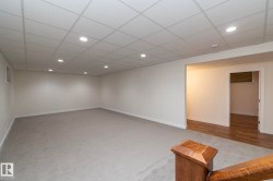 Spacious area featuring light grey carpeting, recessed lighting, and a white drop ceiling - 