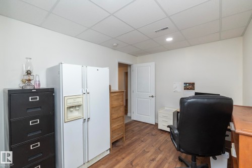 This versatile room features durable wood-look flooring and a white paneled door - 307 Ravine Close, Devon, AB - Indoor Photo Showing Office
