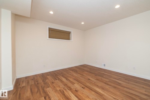 This room features hardwood flooring, light-colored walls, and recessed ceiling lights - 307 Ravine Close, Devon, AB - Indoor Photo Showing Other Room