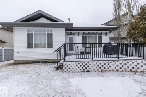 This property features a spacious deck with black railings, accessible via a door from the house - 307 Ravine Close, Devon, AB - Outdoor With Deck Patio Veranda With Exterior