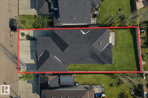 The property features a dark shingled roof, a paved driveway, and a well-maintained lawn - 307 Ravine Close, Devon, AB - Outdoor