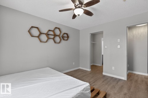 The room features light gray walls, a textured white ceiling, and wood-look flooring - 109 340 Windermere Road, Edmonton, AB 