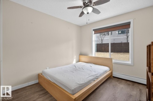 This room features wood-look flooring, a ceiling fan, and a window with a view of the exterior - 109 340 Windermere Road, Edmonton, AB 