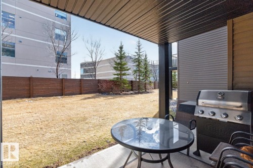 The property features a concrete patio area with an overhead cover, providing an inviting outdoor space - 109 340 Windermere Road, Edmonton, AB 