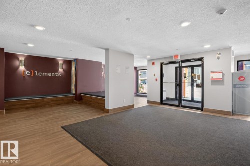 The property features a welcoming common area with recessed lighting and a decorative wall sconce - 109 340 Windermere Road, Edmonton, AB 