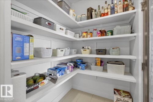 The property features a well-organized pantry with extensive white shelving, providing ample storage space - 606 Reynalds Way, Leduc, AB - Indoor With Storage