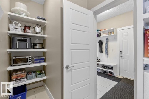 The property features built-in storage shelves and a door with horizontal paneling - 606 Reynalds Way, Leduc, AB - Indoor