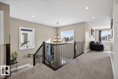 The property features light beige walls, recessed lighting, and windows that provide abundant natural light - 606 Reynalds Way, Leduc, AB - Indoor Photo Showing Other Room