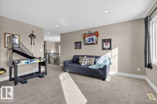 This room features neutral-toned walls, recessed lighting, and carpeted flooring - 606 Reynalds Way, Leduc, AB - Indoor