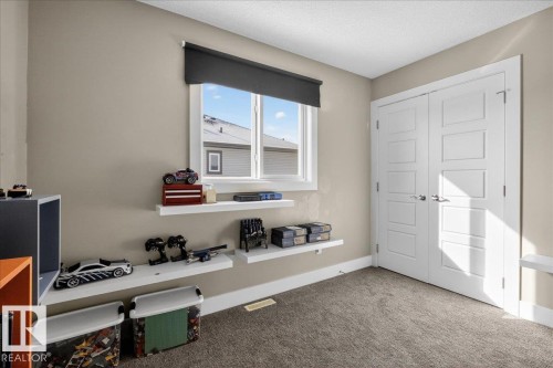 This room features a window with a dark roller blind, white trim, and light beige walls - 606 Reynalds Way, Leduc, AB - Indoor Photo Showing Office
