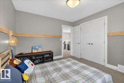 A comfortable room featuring gray walls, carpeted flooring, and white trim - 606 Reynalds Way, Leduc, AB - Indoor Photo Showing Bedroom
