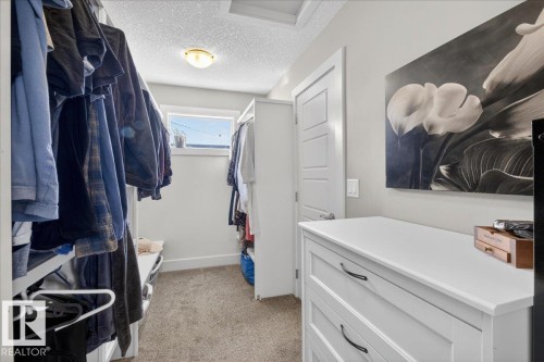 This closet features ample storage with hanging rods and shelving, a window for natural light, and a dedicated dresser for additional organization - 606 Reynalds Way, Leduc, AB - Indoor With Storage