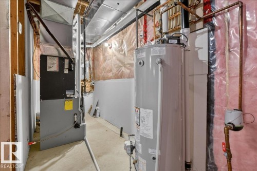 Utility area featuring a water heater, furnace, and exposed copper piping - 606 Reynalds Way, Leduc, AB - Indoor Photo Showing Basement