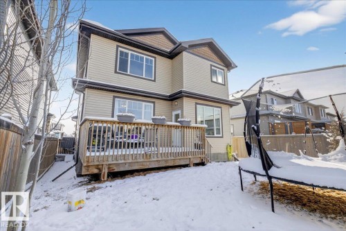 The property features a rear wooden deck and a fenced yard - 606 Reynalds Way, Leduc, AB - Outdoor With Deck Patio Veranda