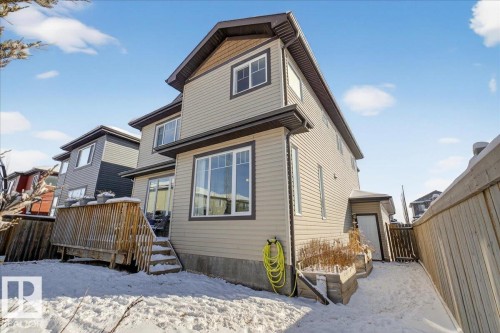 The property features a two-story exterior with light-colored siding and dark trim - 606 Reynalds Way, Leduc, AB - Outdoor