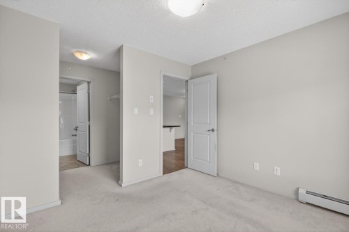 The room features plush carpeting and light-colored walls, creating a bright and inviting atmosphere - 426 390 Windermere Road, Edmonton, AB - Indoor Photo Showing Other Room