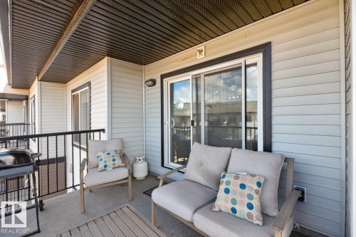 The property includes a private balcony with concrete flooring, accented by light-colored siding and a dark soffit - 426 390 Windermere Road, Edmonton, AB - Outdoor With Deck Patio Veranda With Exterior
