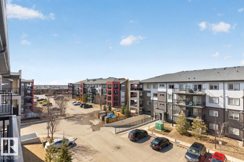 View of the surrounding community featuring residential buildings with balconies and ample parking - 426 390 Windermere Road, Edmonton, AB - Outdoor With Balcony