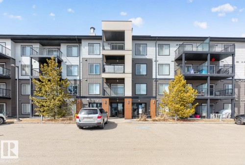The property features a modern exterior with varied siding textures and colors, including white, gray, and dark gray panels, complemented by brown wood-look accents - 426 390 Windermere Road, Edmonton, AB - Outdoor With Balcony With Facade