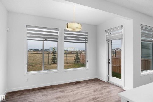 This room features hardwood style flooring, white walls, and a modern ceiling light fixture - Edmonton, AB - Indoor Photo Showing Other Room