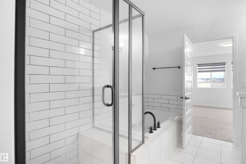 Bathroom featuring a glass-enclosed shower with subway tile, a bathtub with matte black fixtures, and white tile flooring - Edmonton, AB - Indoor Photo Showing Bathroom