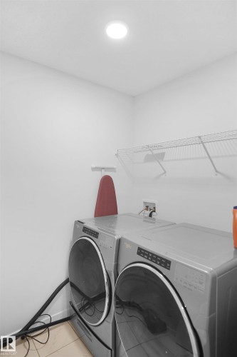 Laundry area featuring overhead lighting and wall-mounted shelving - Edmonton, AB - Indoor Photo Showing Laundry Room