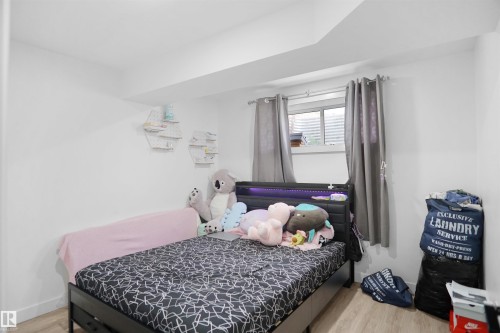 This room features light-colored walls and wood-look flooring, creating a bright and inviting atmosphere - Edmonton, AB - Indoor Photo Showing Bedroom